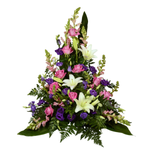 En blomsterarrangemang i form av en triangel med rosa rosor, vita liljor och lila blommor, omgivna av gröna blad.